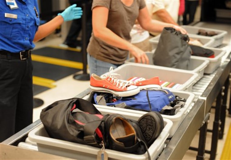 In this Aug. 3, 2011 photo, airline passengers retrieve their scanned belongings while going through the Transportation Security Administration security checkpoint at Hartsfield-Jackson Atlanta International Airport, in Atlanta. 